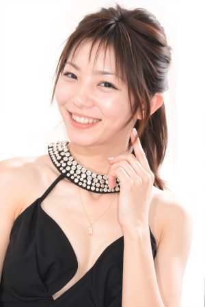 白い背景のスタジオ設定でカメラに向かってポーズをとる、陽気な表情を持つ若いアジア人女...。