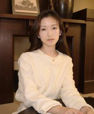 画像の中央にある木製のテーブルに座っている、正面からのポートレート カメラの角度から...。