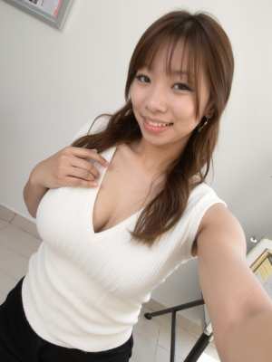 白い部屋で自信を持ってポーズをとる若い女性を自撮りアングルから撮影した写実的な写真。