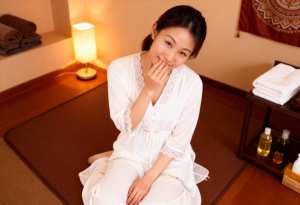 白いローブを着てスパのマットに座っている女性を正面カメラのアングルから写実的に撮影したもの。