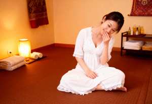 スパのような雰囲気の畳に座る若い女性。