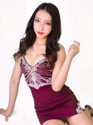 ブルゴーニュの短いドレスを着てエレガントにポーズをとる若い女性を、正面カメラのアング...。