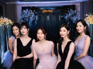 花やスパンコールで飾られた豪華なエントランスの前で、フォーマルな服装に身を包んだアジ...。