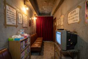 コンクリートの壁と赤いカーテンのある薄暗い部屋。