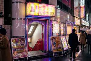 日本の東京の雨の夜景を写実的に描写したもので、ネオンが輝くコンビニエンスストアの入り...。