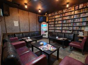 部屋の中央にあるコーヒーテーブルを中心に、黒革張りのソファと赤い革張りの椅子が半円状...。