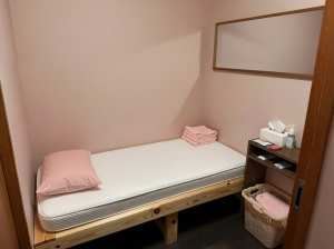 ミニマリスト デザインの小さな寝室を写実的にレンダリングしたもので、木のフレームと白...。