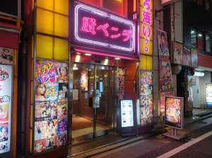 夜のネオンに照らされた日本の映画館の外観の写真。