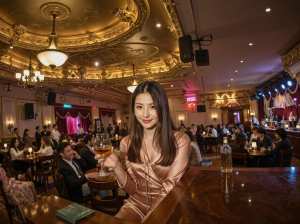 豪華で華やかなレストランで大勢の人々に囲まれ、バーに座ってワインを持っている女性を正...。