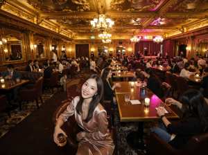 華やかな金枠の天井とシャンデリアのある豪華なレストランを正面から写実的に撮影したもの...。