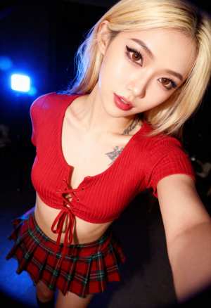 赤いクロップトップとチェック柄のミニスカートを着て自撮りをする若い女性を自撮りアング...。