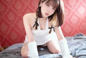 柔らかい質感の赤い壁を背景に、ベッドの上でポーズをとる若い女性を正面から写実的に撮影...。