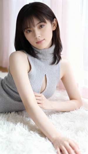 カットアウトのディテールが施されたグレーのノースリーブ タートルネック セーターを着...。