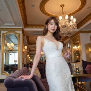 豪華なリビング ルームでシャンパン グラスを持ったウェディング ドレスを着た女性を正...。