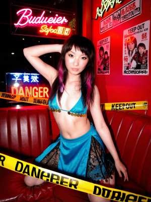 ネオンが輝くナイトクラブの環境で自信を持ってポーズをとる若い女性を、正面カメラのアン...。