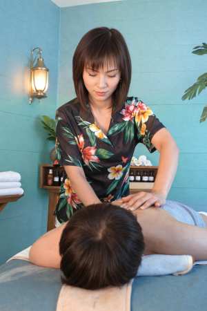 スパ環境で男性にマッサージをする女性を正面カメラのアングルから撮影した写実的な撮影。