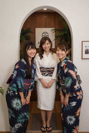 伝統的な和服を着た 3 人の女性が植物を背景にアーチ道で写真を撮る、正面カメラのアン...。