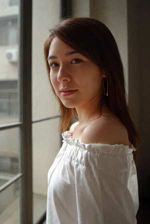 長い茶色の髪を持つ若い女性の写実的なポートレート。