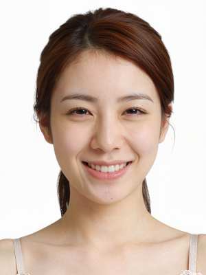 明るい表情で、わずかな笑みを浮かべて視聴者をまっすぐに見つめている若い女性のクローズ...。