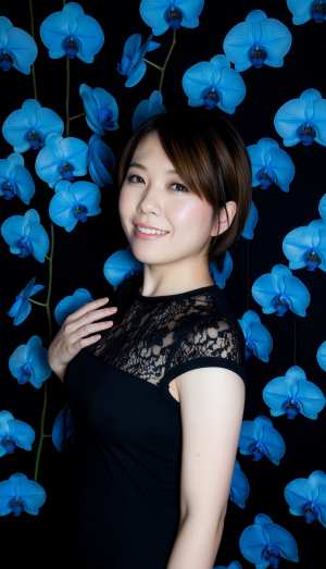 青い蘭の花に囲まれた若い女性のポートレートをポートレート カメラ アングルから撮影したもの。