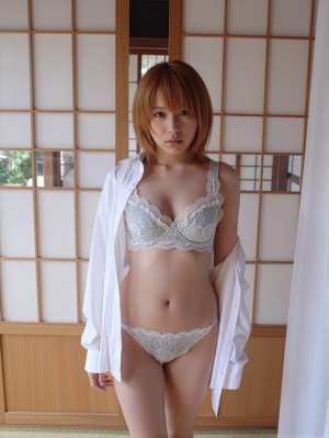 伝統的な和室の襖の前で自信を持って立っている、白いレースのブラジャーとパンティを着て...。