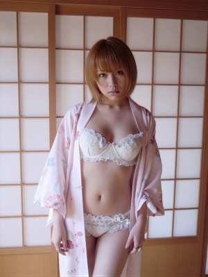 花柄の着物とランジェリーを着て伝統的な和室に立つ若い女性を正面カメラのアングルから写...。