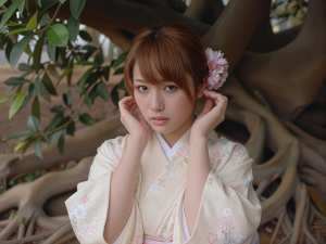 花柄の伝統的な日本の着物を着た、白い肌と茶色の髪の若い日本人女性の写実的なポートレート。