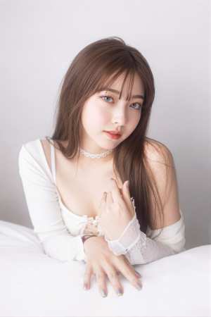 レースのディテールが施された白いオフショルダーのトップスを着て、白い表面でポーズをと...。