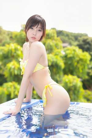 黄色いビキニを着てプールサイドでポーズをとる若い女性を横から撮った写実的な写真。