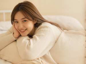 ベッドに横たわり、リラックスした表情でカメラに微笑む若い女性の写実的なポートレート。