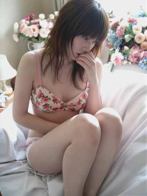 居心地の良いリビング ルームの白いソファに座り、ピンクの花柄のブラとお揃いのパンティ...。