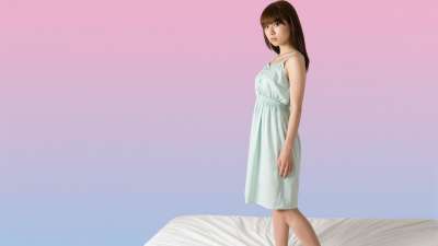 ピンクとブルーのグラデーション背景に立つ若い女性のポートレート