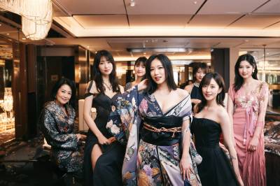 豪華なホテルのロビーで写真を撮る7人の女性グループ。