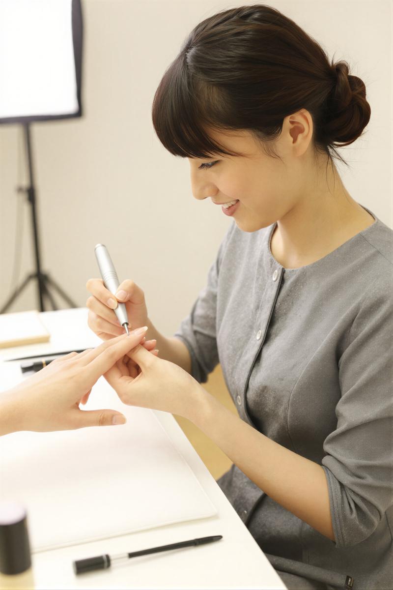 電動ファイルで爪を整えるネイリスト