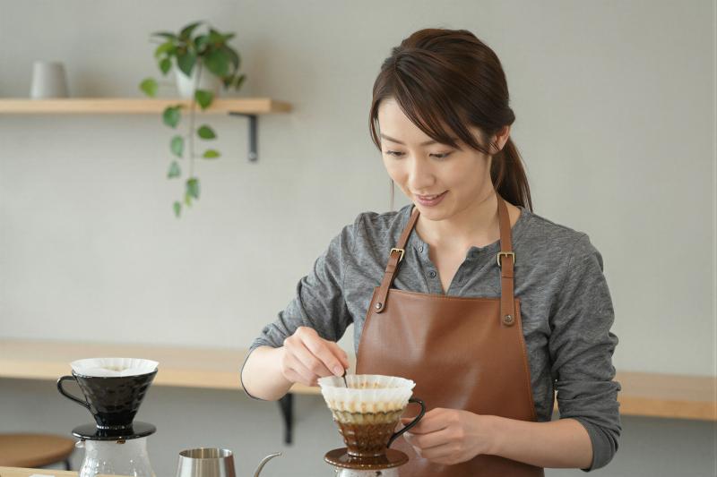 モダンカフェでハンドドリップする女性