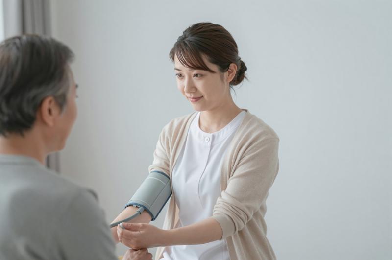 在宅医療で血圧を測る看護師