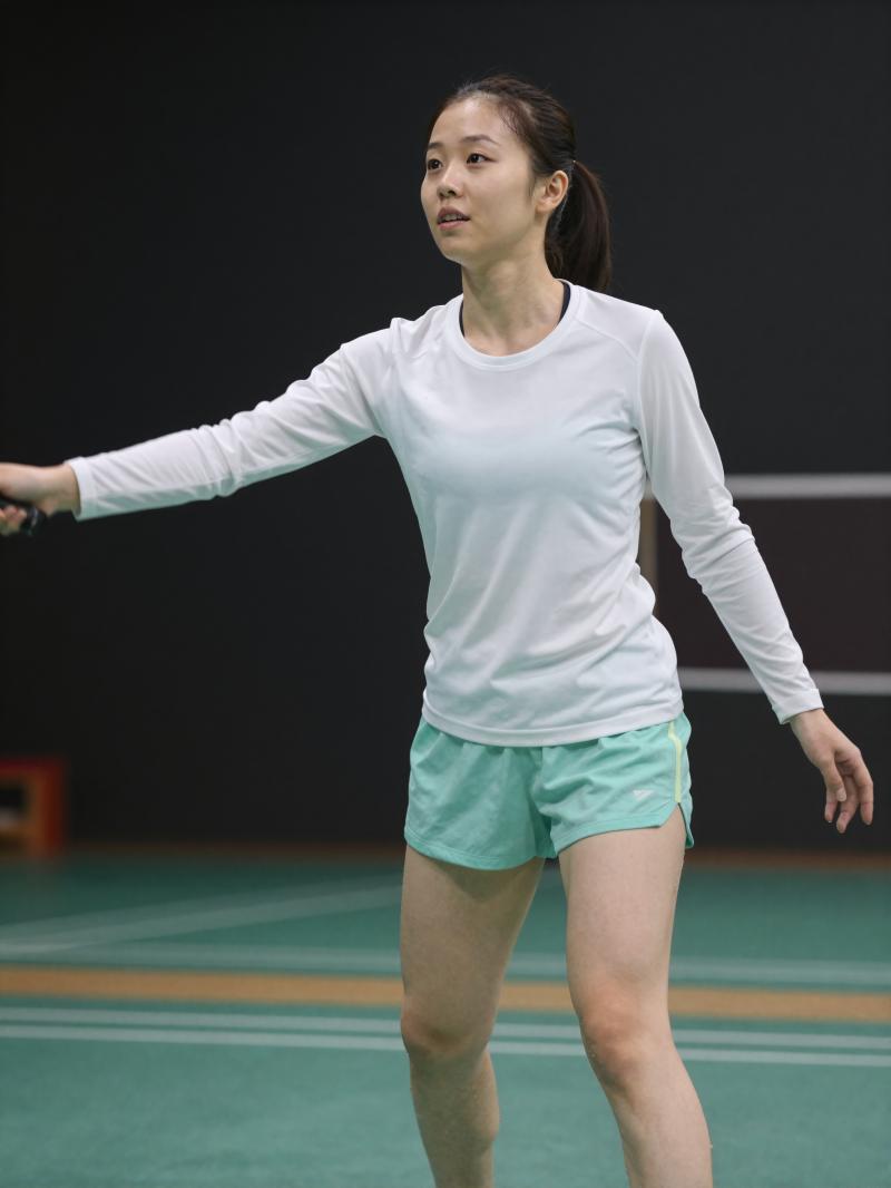 体育館でバドミントンを楽しむ女性