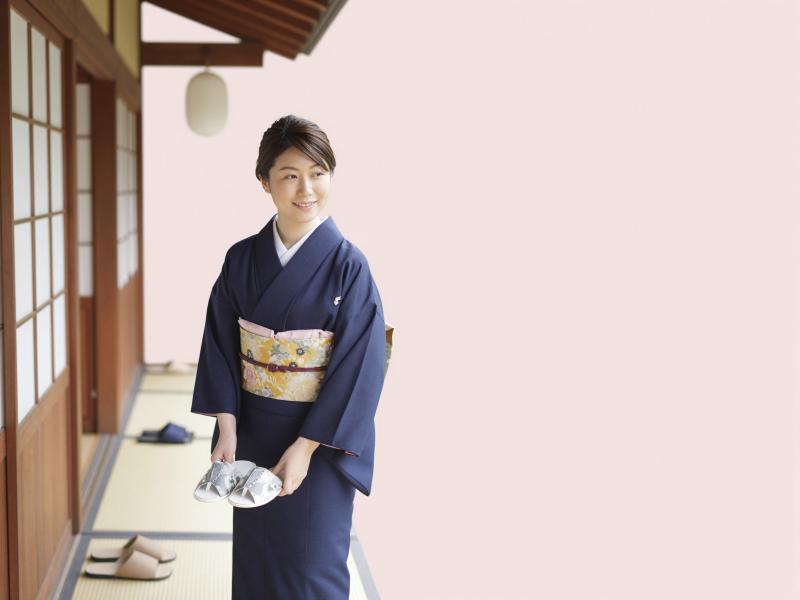 旅館の玄関で履物を整える女性