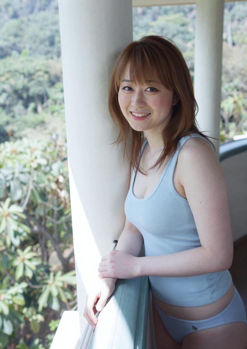 緑のタンクトップ姿で部屋に佇む女性