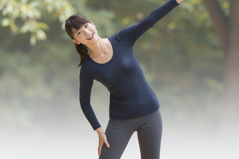 公園でストレッチするリラックスした女性