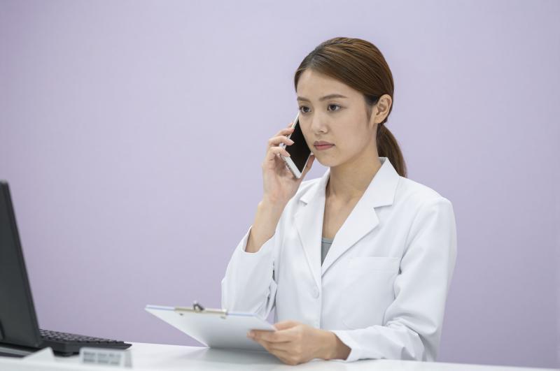 薬局で電話応対する薬剤師