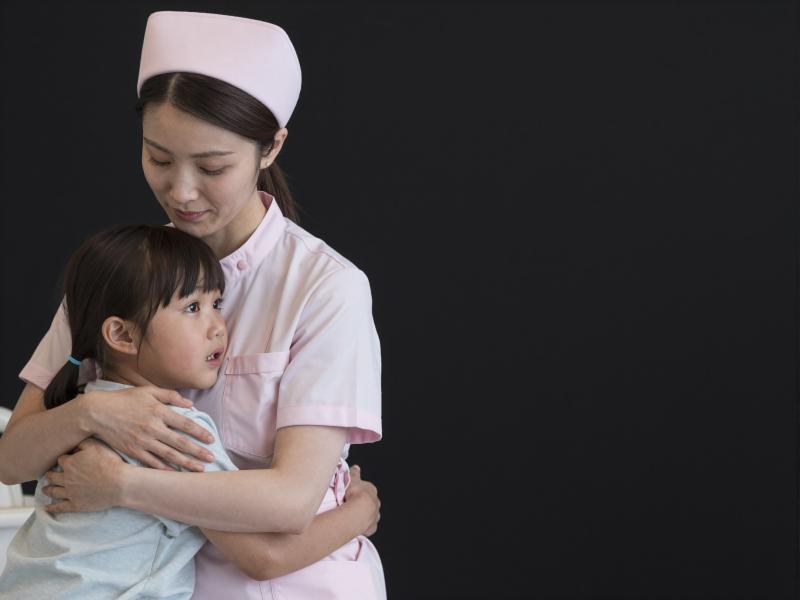 小児病棟で子供を抱きしめる看護師