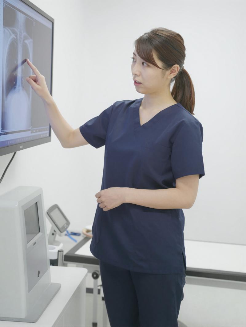 診察室でX線画像を説明する医師