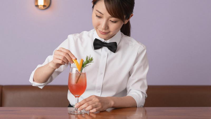 バーでカクテルを丁寧に飾るバーテンダー