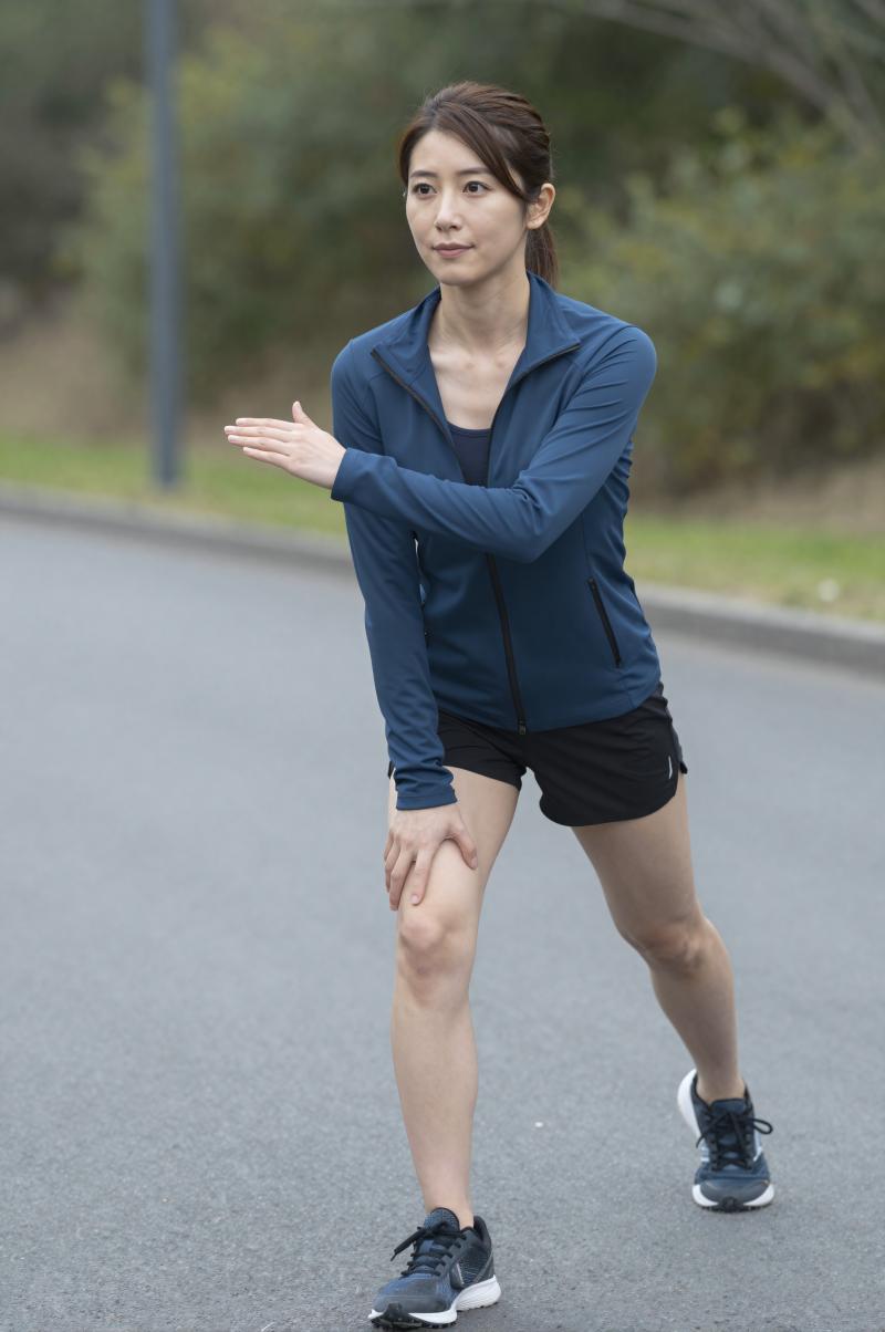 屋外でダイナミックストレッチをする男性