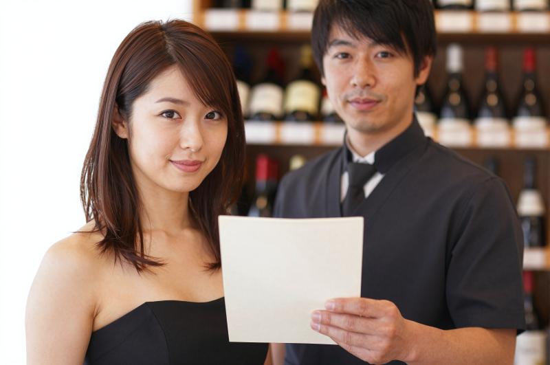 ワインリストを掲げるソムリエの顔