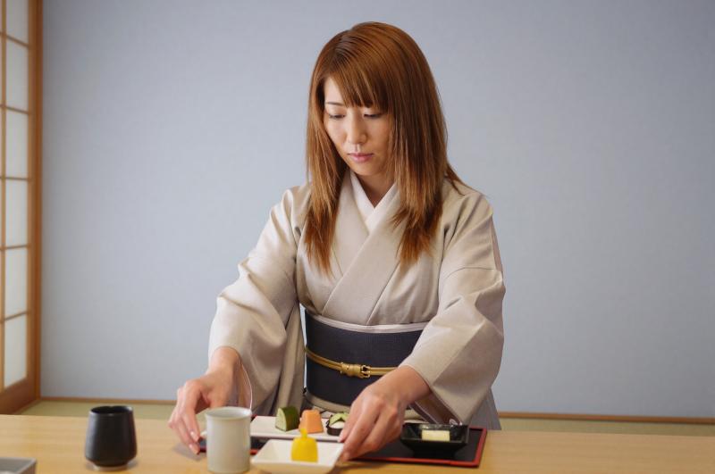 旅館で懐石料理を提供する女性