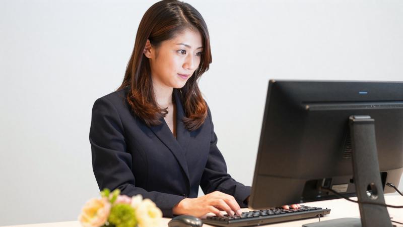 ホテル受付でPCを操作する女性