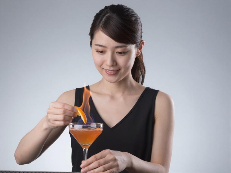カクテルに火を灯すバーテンダー
