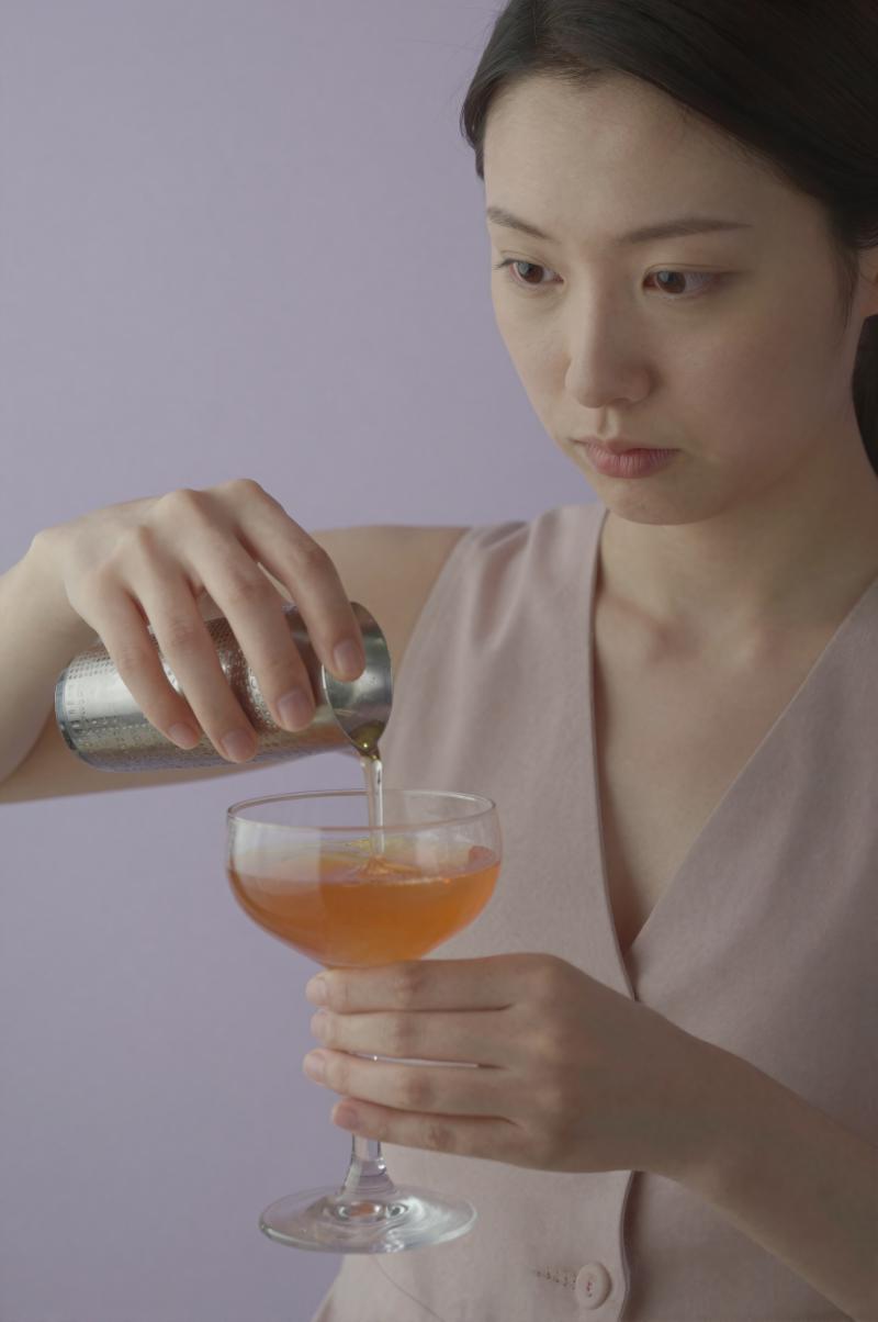 層状カクテルを注ぐバーテンダー